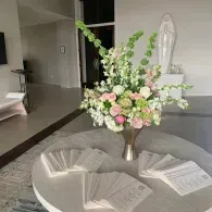 Round table with flower arrangement and open books in a modern room