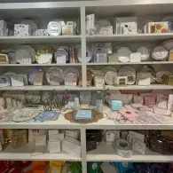 Shelves filled with plates, cups, and dishware in a kitchen or display cabinet.