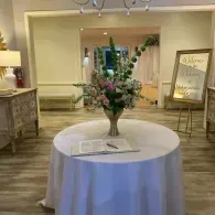 Round white table with flower vase in a decorated indoor event room