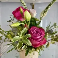 Pink and white floral bouquet with roses and greenery in a vase