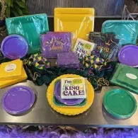 Mardi Gras gift display with purple, green, and gold king cake-themed treats and packages