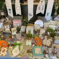 Assorted decorated cookies and treats displayed on a table with floral accents and monogrammed pennants