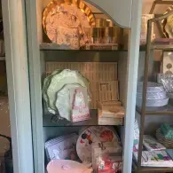 Glass cabinet with decorative plates, baskets, and folded linens on shelves