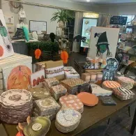 Display table of colorful craft items and Halloween decorations in a shop or market.