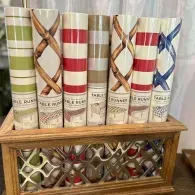 Decorative stack of patriotic red, white, and blue book spines in a wooden holder on a shelf