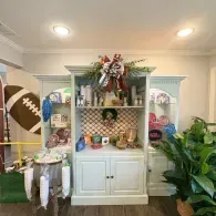 Football-themed buffet display with candy, wreath, lanterns, and green plants on either side