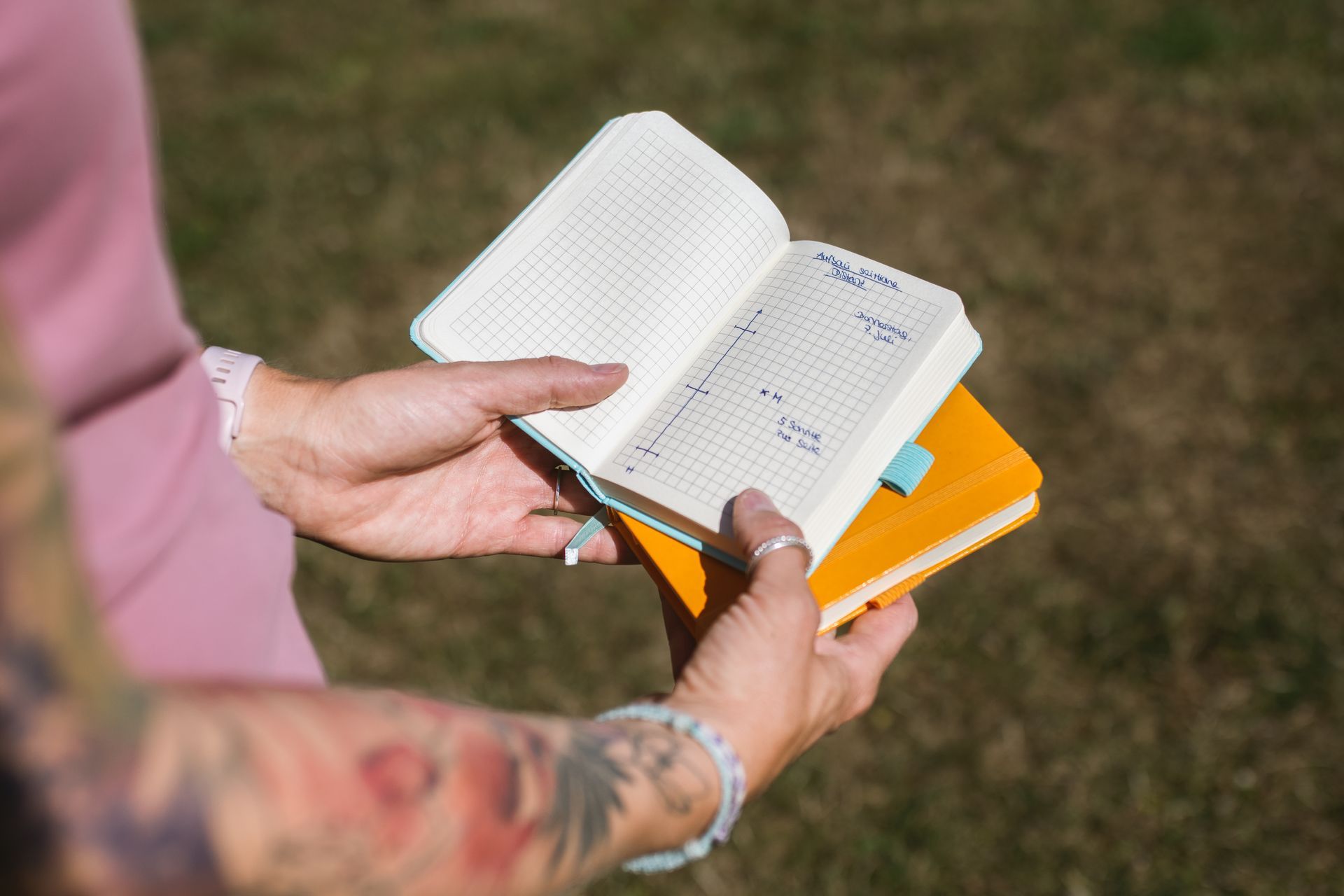 Hände einer Frau, die ein Notizbuch mit Hoopers Parcours hält