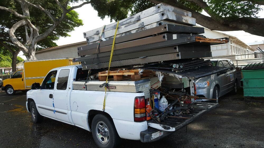 A white truck with a stack of wood in the back A white truck with a stack of wood in the back