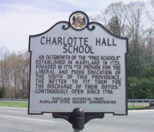 Historic Charlotte Hall School roadside marker with black text on a white sign in a grassy field. Historic Charlotte Hall School roadside marker with black text on a white sign in a grassy field.