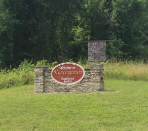 Welcome to Connersville sign beside a roadside in a grassy, wooded area Welcome to Connersville sign beside a roadside in a grassy, wooded area