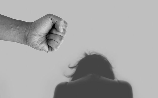 Man with angry fist behind woman