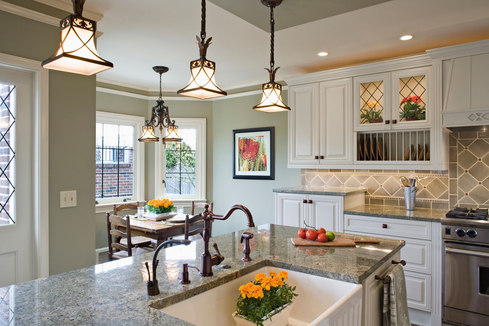 Kitchen with white cabinets, granite countertop, bay window, and three pendant lights.
