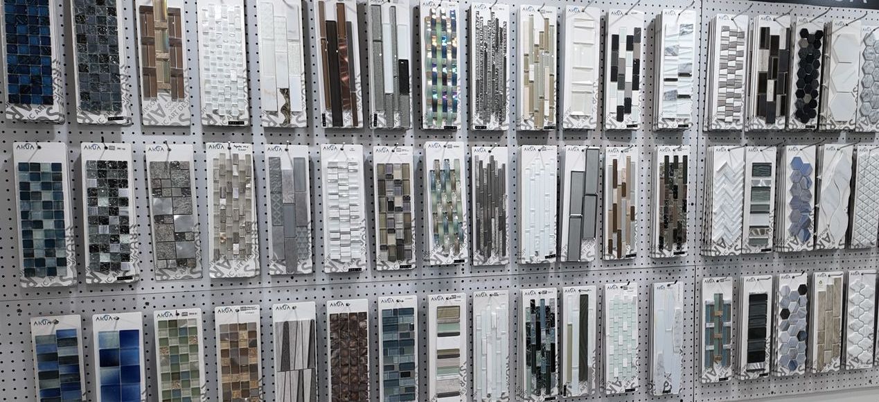 Display of various tile samples on a pegboard, showcasing different colors and textures.