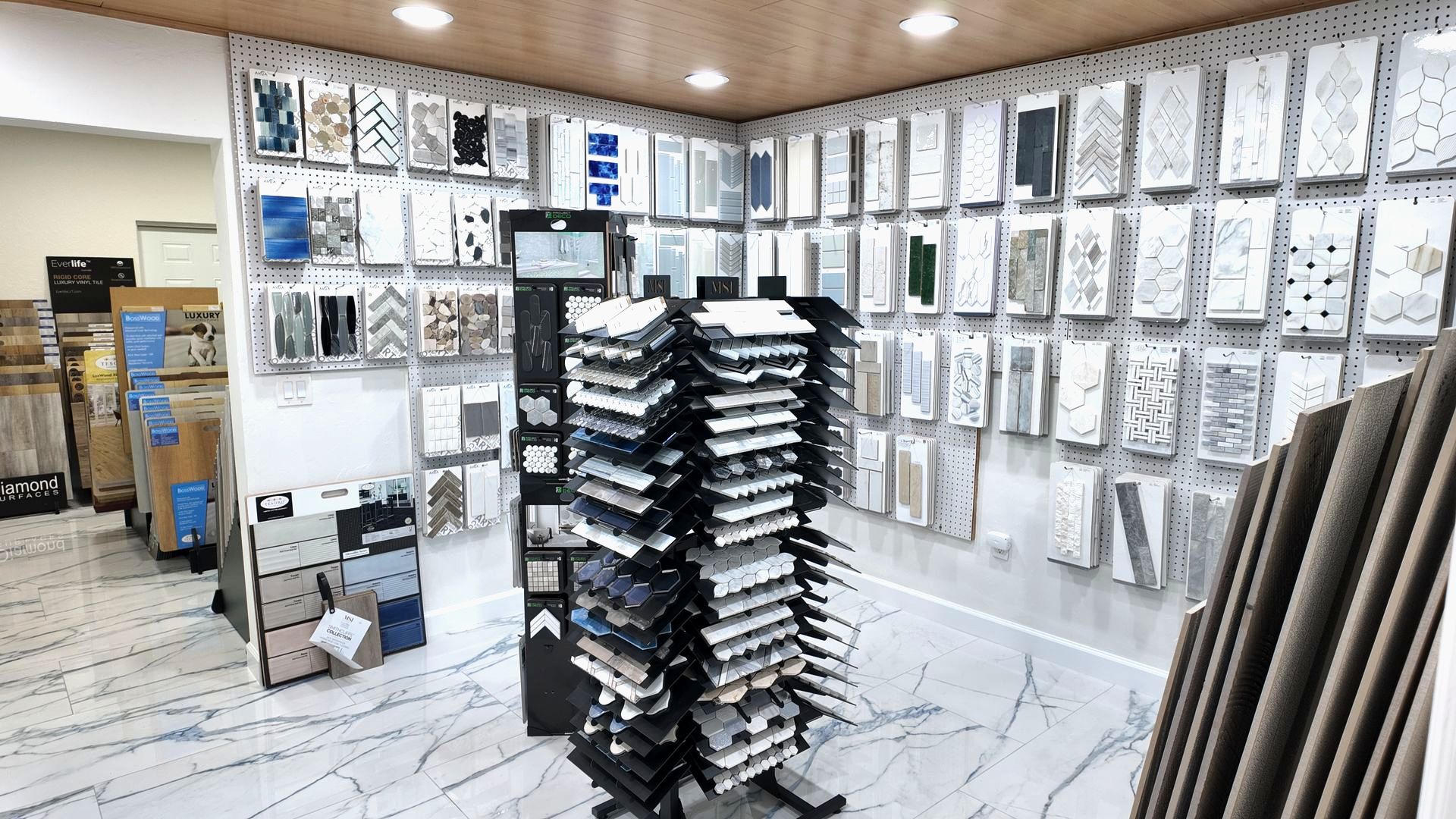 Tile showroom interior with samples displayed on walls and racks.