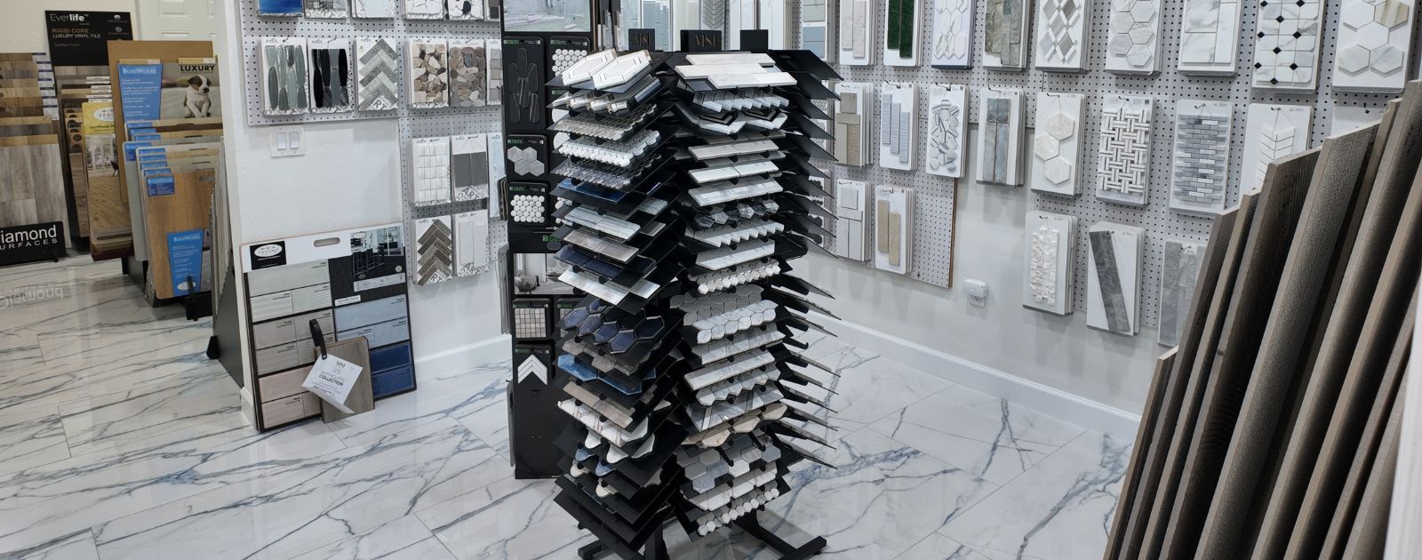 A tile store interior showing samples on display stands and wall-mounted boards.