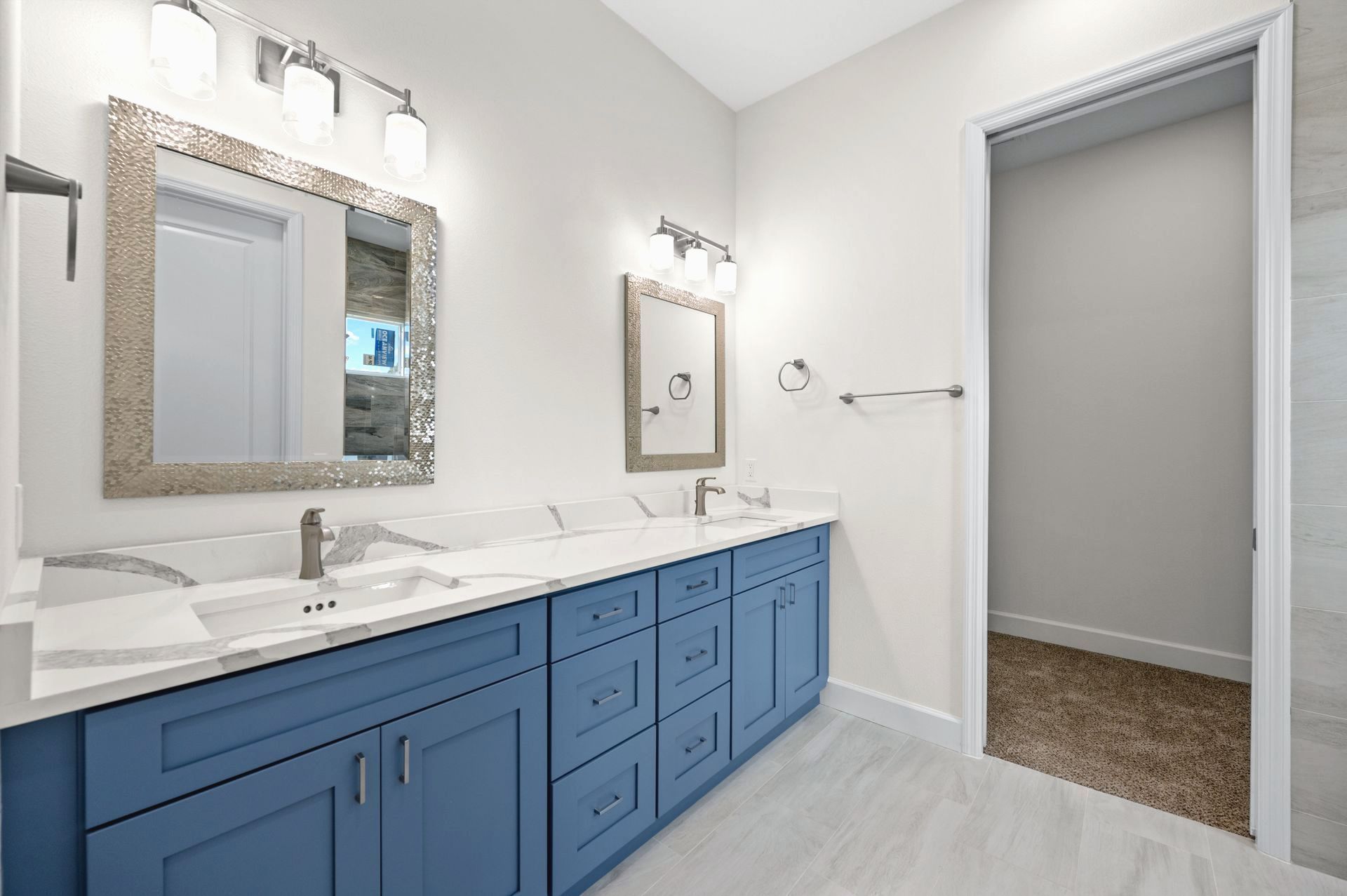 Brand new Bathroom remodel in Siest Key with Blue vanity with marble counters and silver fixtures in a modern bathroom.