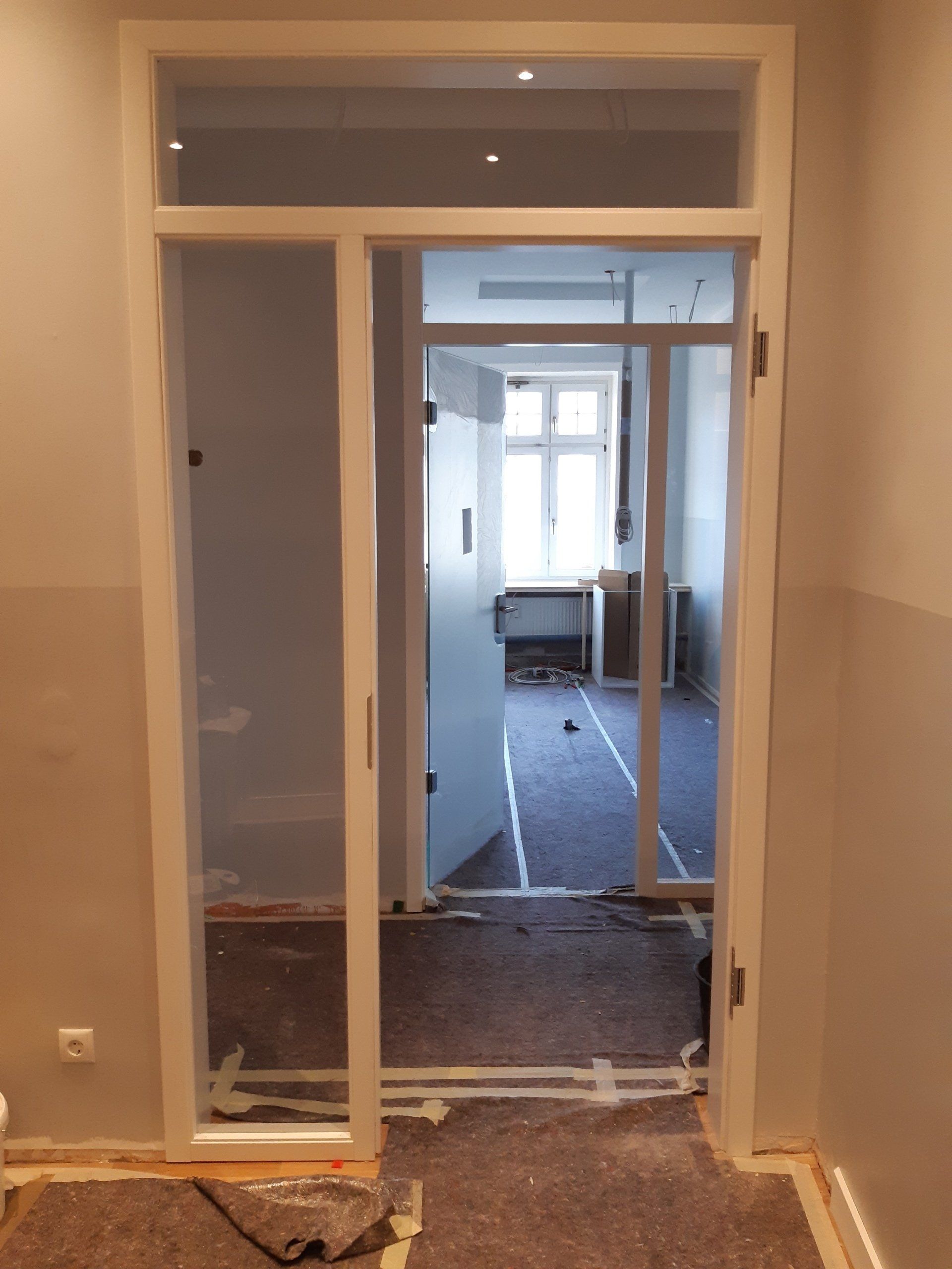 Ein Raum mit einer Glasschiebetür, die zu einem anderen Raum führt