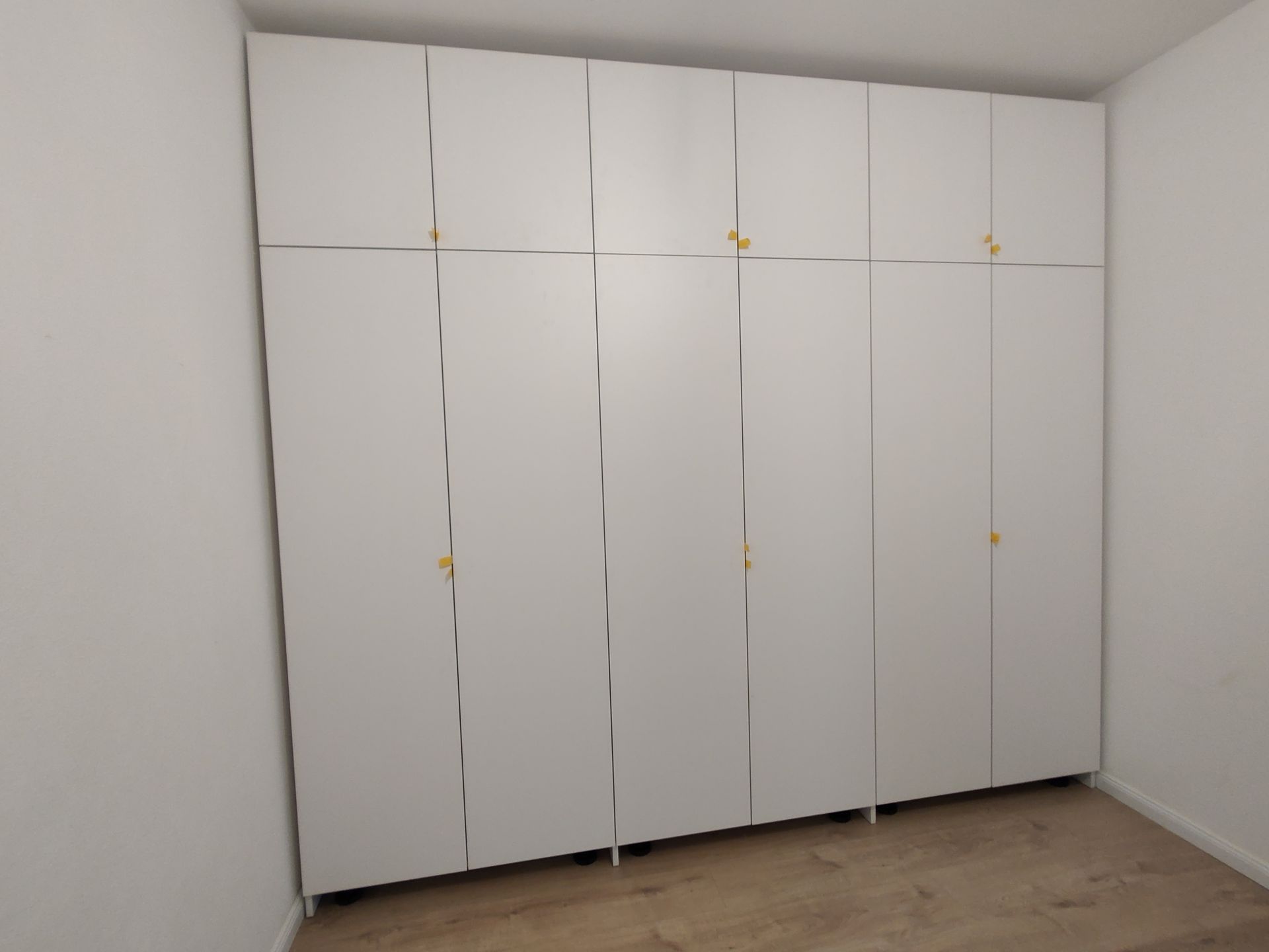 Ein Raum mit vielen weißen Schränken und Holzböden