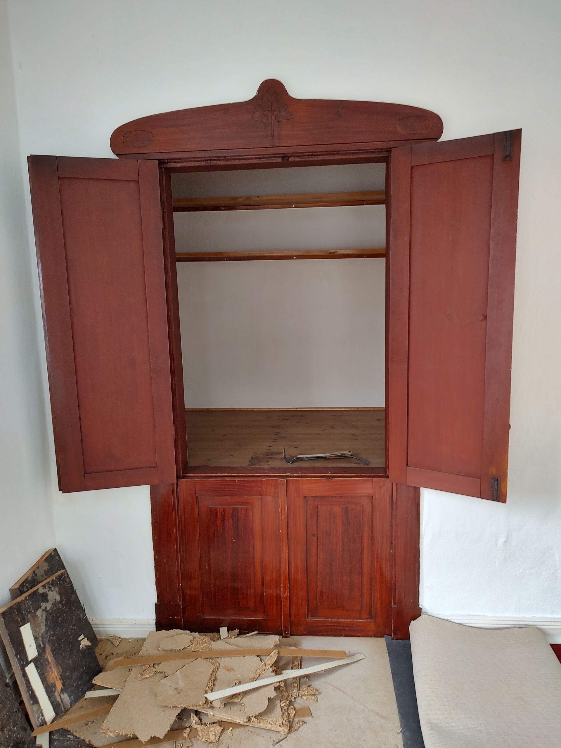 Ein leerer Raum mit einer Holztür und offenen Fensterläden.