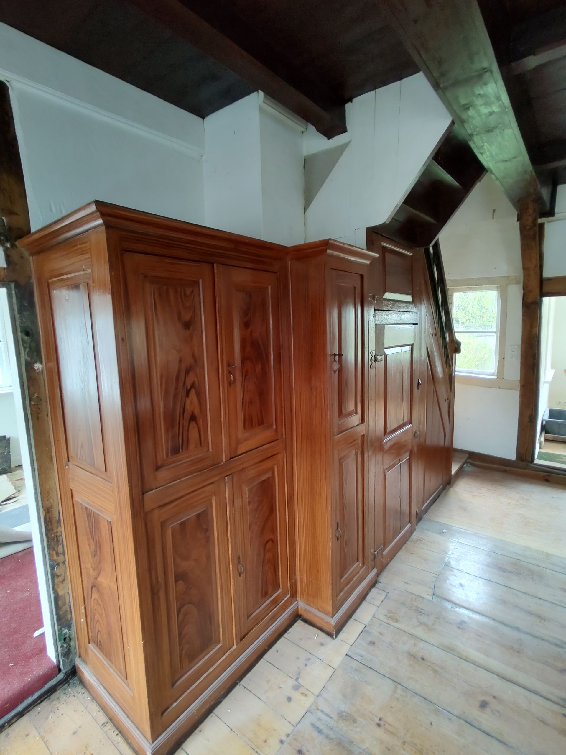 Ein Raum mit vielen Holzschränken und Treppen