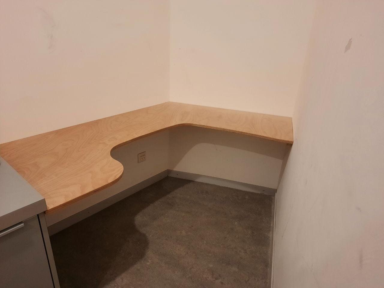 Ein leerer Raum mit einem Holzschreibtisch in der Ecke.