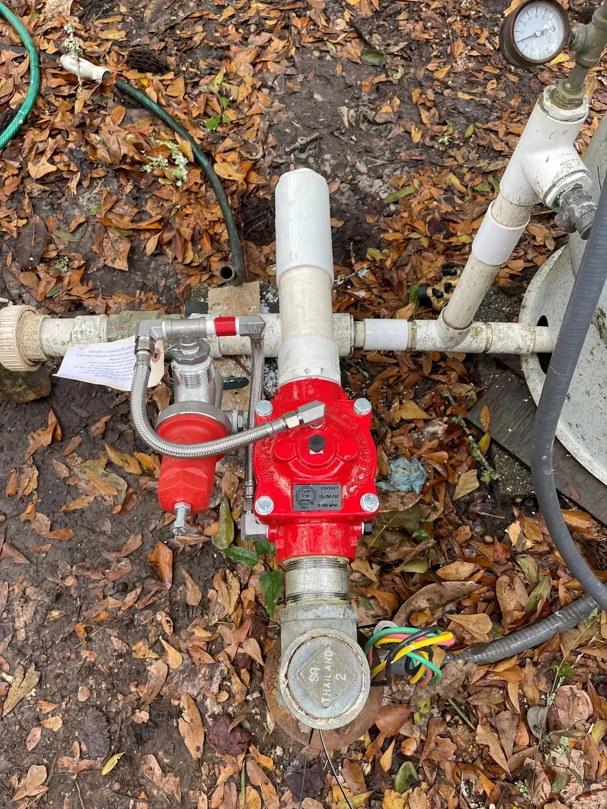 A water pump is sitting in the middle of a field.
