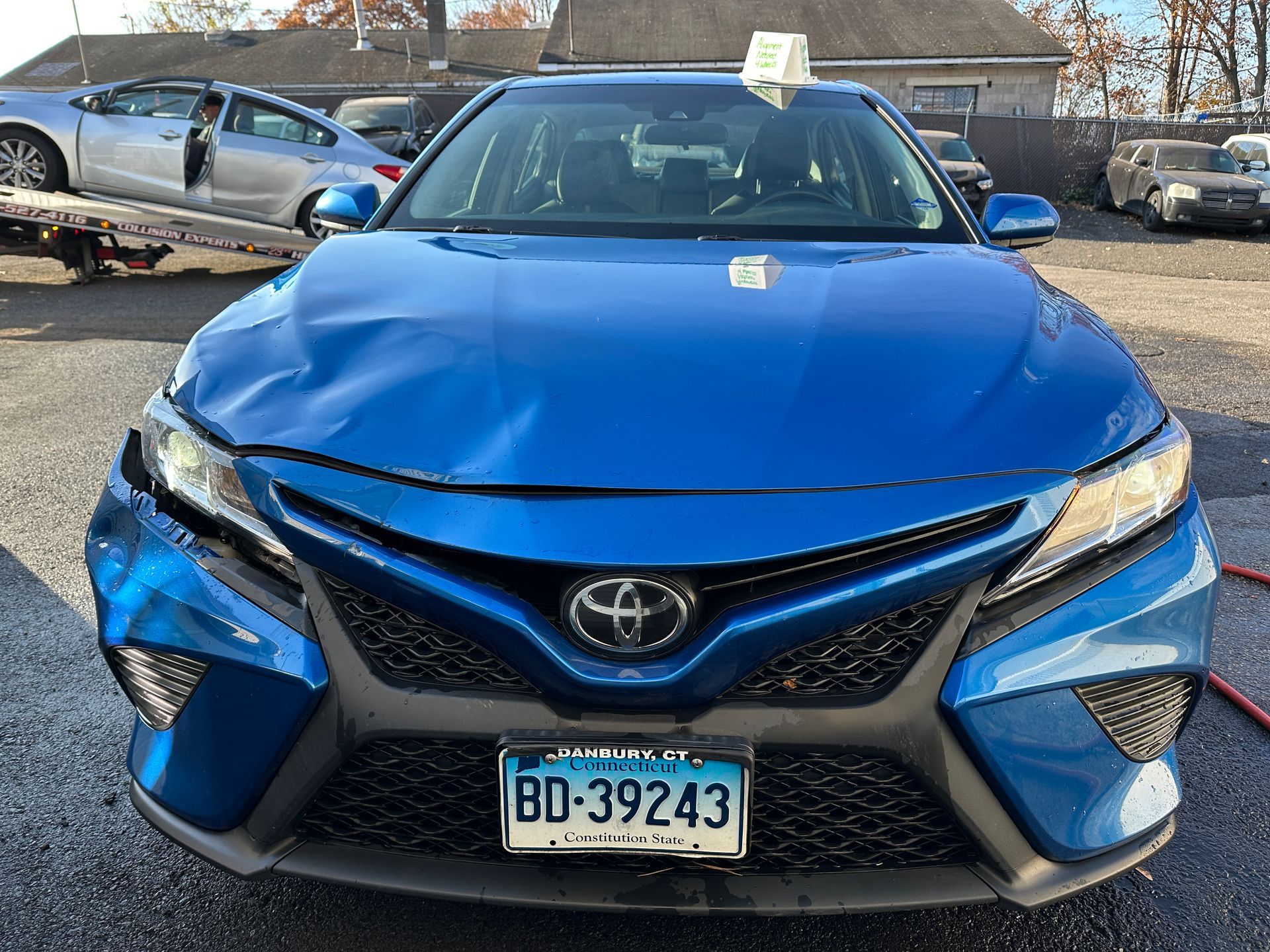 A blue car with front end damage