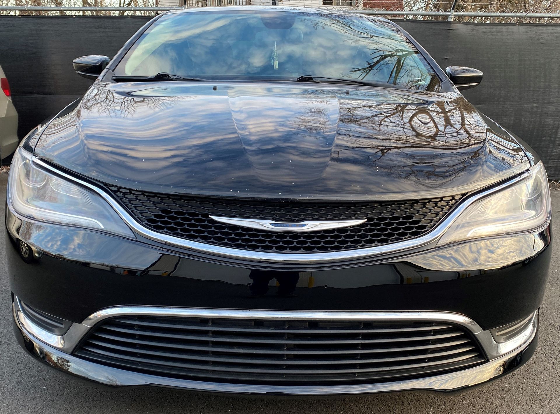 A black chrysler pacifica is parked in a parking lot.