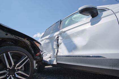 A white car has been damaged in a car accident.
