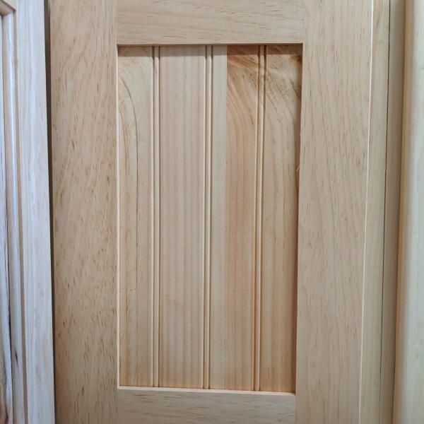 Close-up of a light wood cabinet door with a recessed panel.