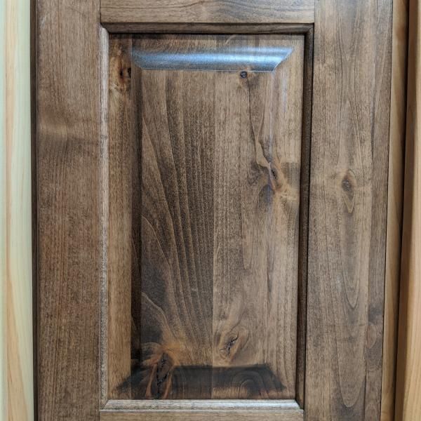 Wooden cabinet door with a recessed rectangular panel and natural wood grain finish