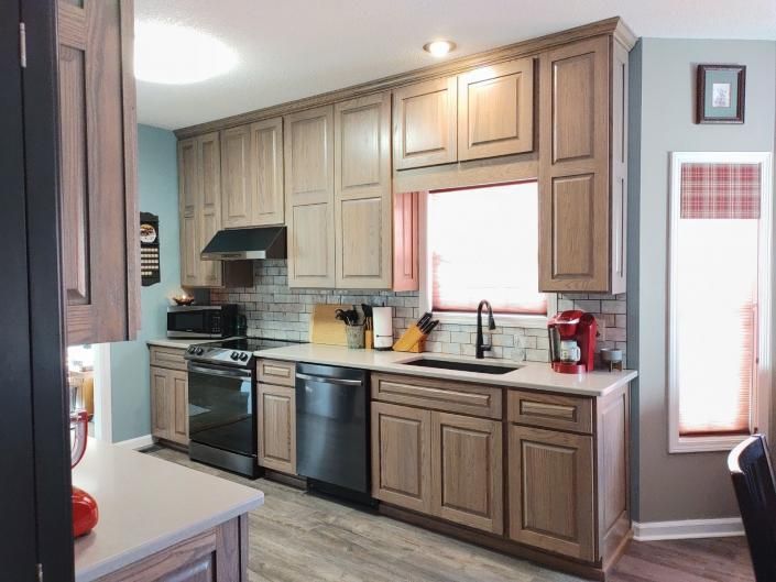 Modern kitchen with beige cabinets, stainless steel appliances, and a bright window above the sink