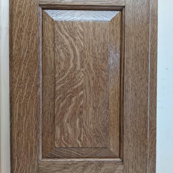 Wooden cabinet door with a raised panel and brown wood grain finish
