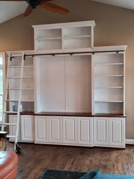 Built-in white entertainment center with shelves, cabinets, and a central TV space in a living room