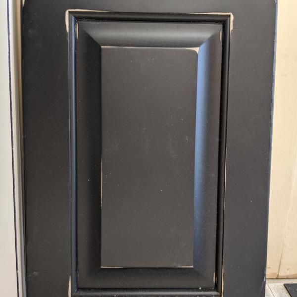 Black rectangular recessed wall panel or switch plate with a dark center and beveled frame.