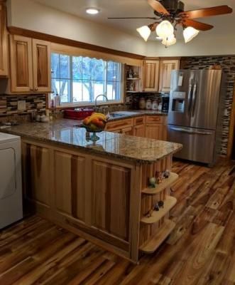 Modern kitchen with wood cabinets, granite island, stainless steel appliances, and hardwood floors