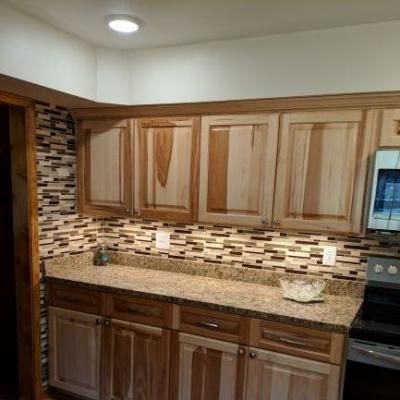 Modern kitchen with wood cabinets, granite countertop, and mosaic tile backsplash