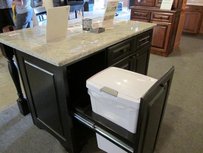 Kitchen island with a beige countertop and a white cooler stored on a pull-out shelf underneath.