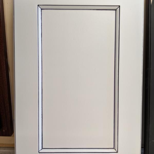 White paneled cabinet door with a silver trim border