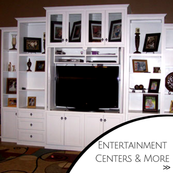 White built-in entertainment center with TV, shelves, cabinets, and decor in a living room.