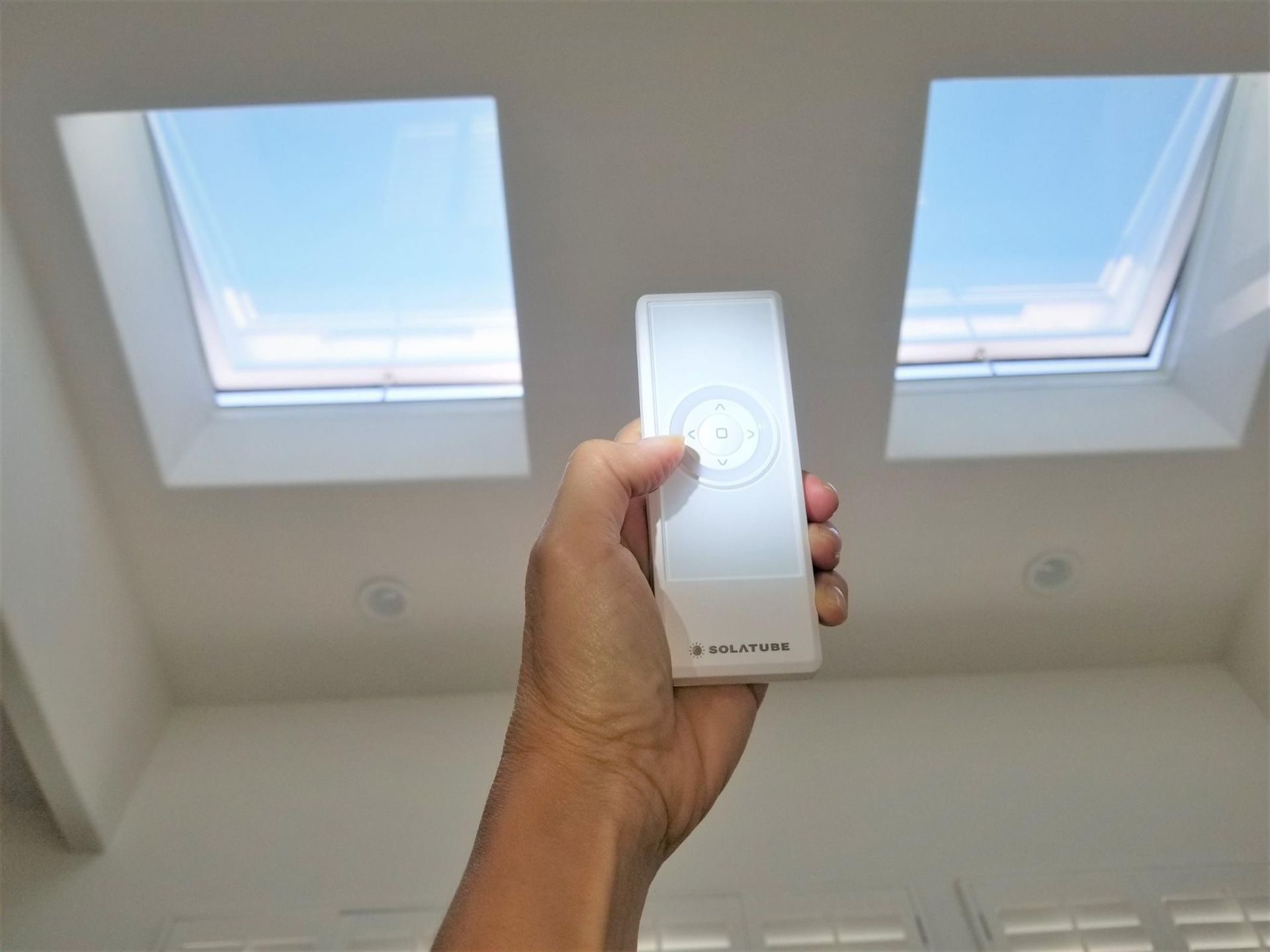 A Person Is Holding A Remote Control In Front Of Two Skylights — The Woolmen In Casino, NSW