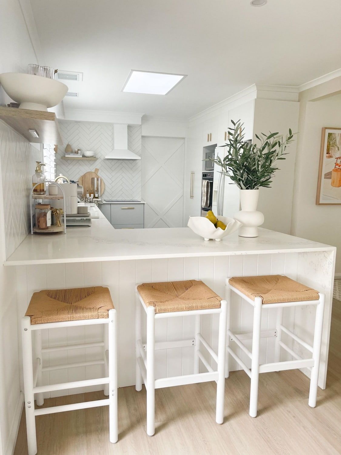 A Kitchen With A Bar And Stools And A Plant On The Counter — The Woolmen In Byron Bay, NSW