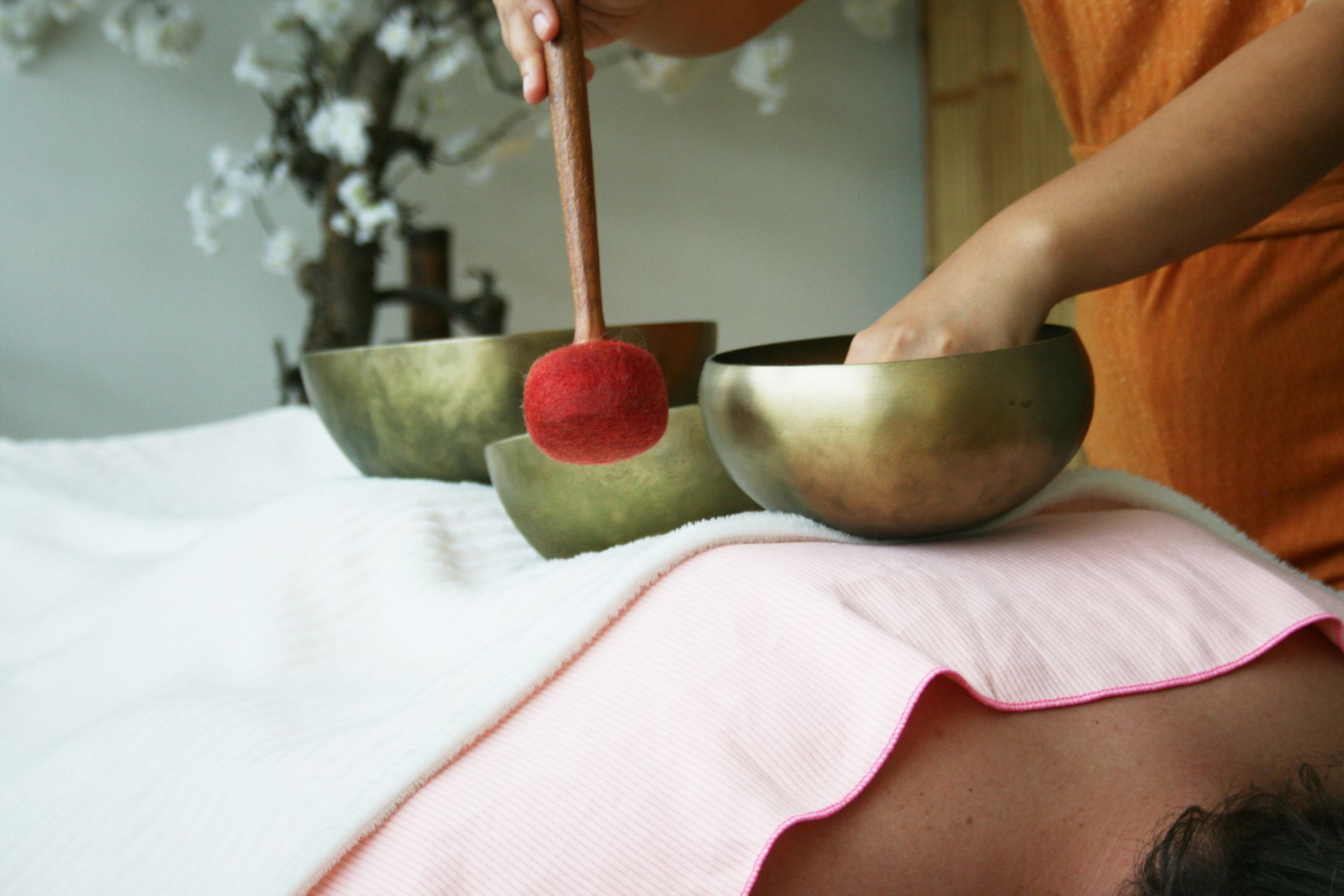A man is receiving a energetic sound healing with Reiki and Koshi.