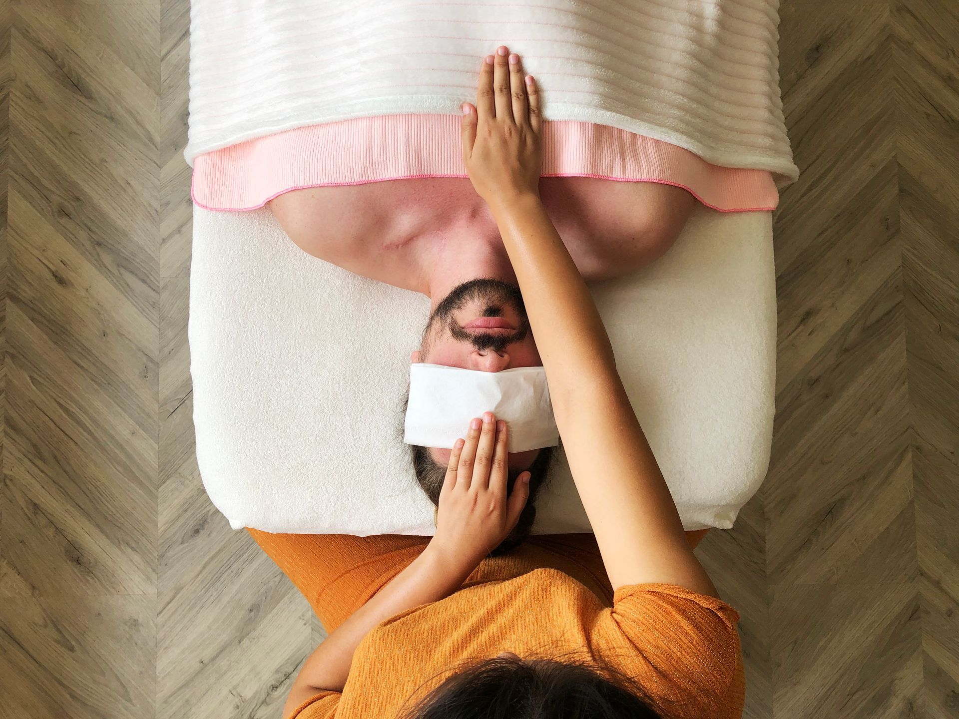 Merlinna is giving a man an energetic Reiki session on his chest.