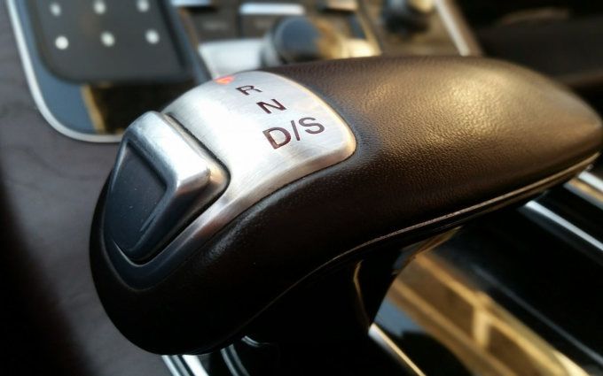 Close-up of a car's automatic gear shift lever with PRNDS markings.