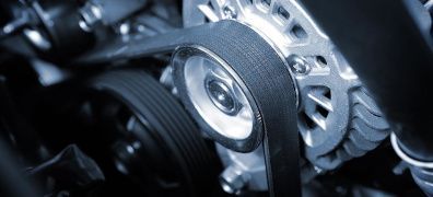 Close-up of a car engine timing belt and pulleys with metal gears and components