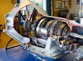 Cutaway view of a shiny mechanical turbine assembly inside a metal frame on a workbench