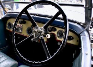 Vintage car interior with large steering wheel and cream dashboard details