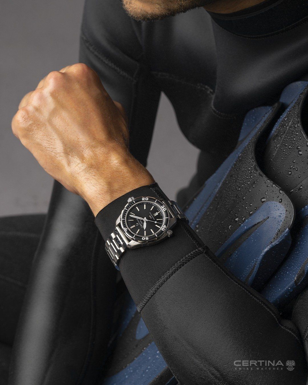 Een man in een wetsuit draagt een horloge om zijn pols.