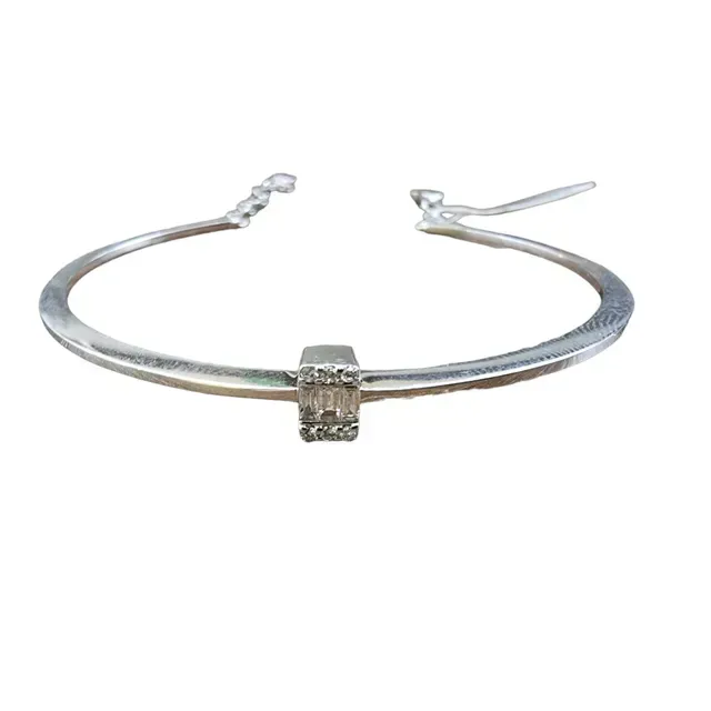 Een zilveren armband met een vierkante steen in het midden